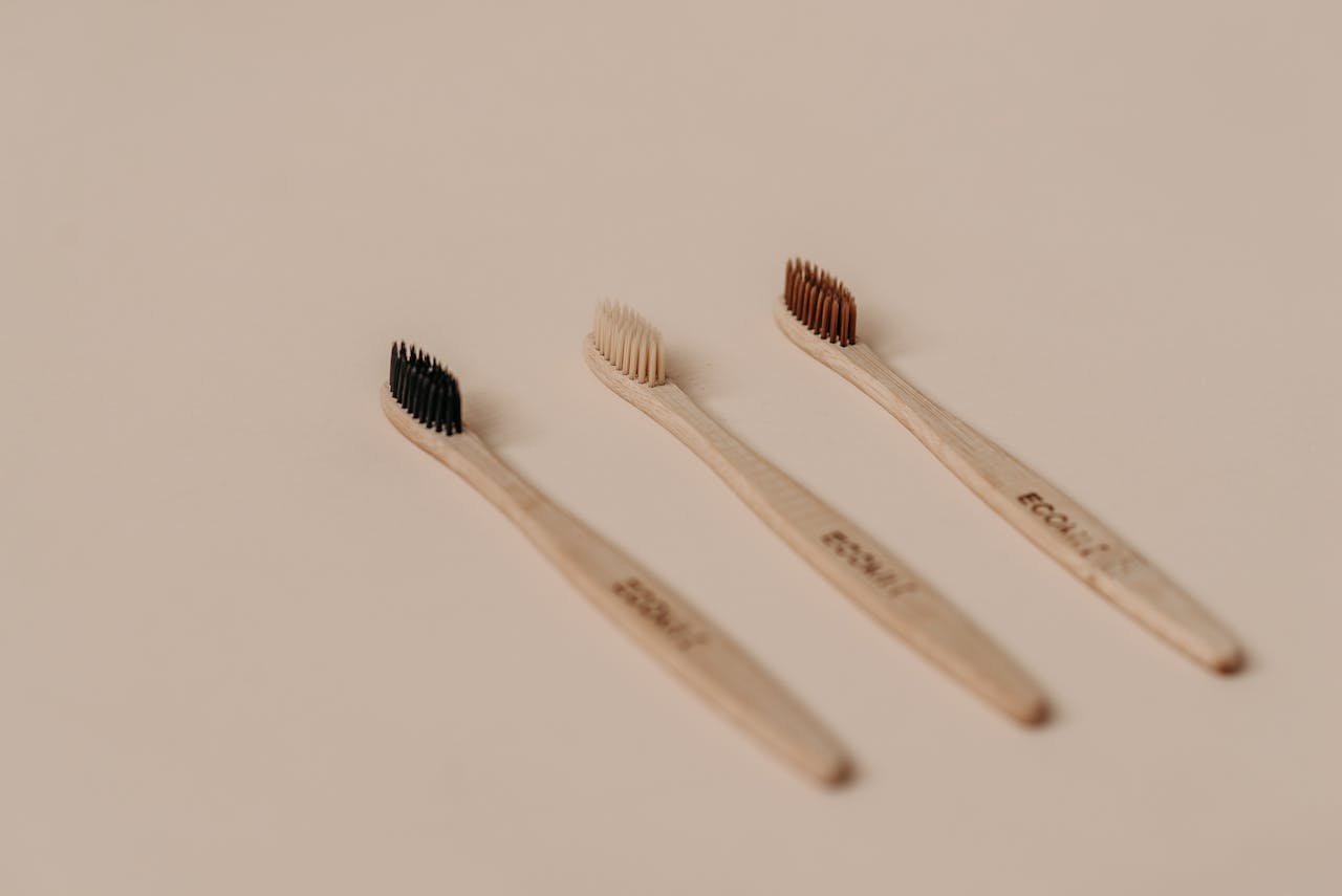 Set of eco-friendly bamboo toothbrushes on a neutral background.