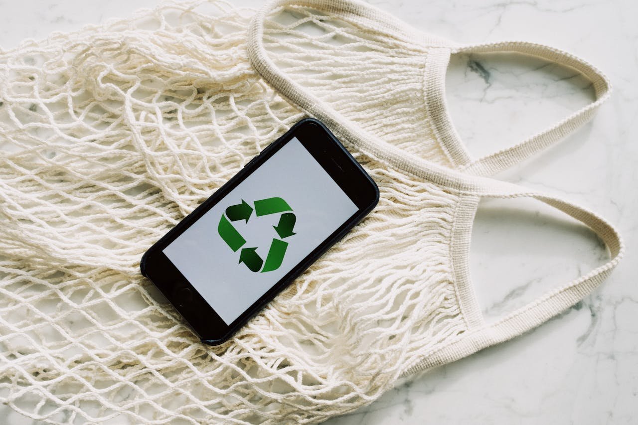 A smartphone displaying a recycle symbol on a mesh bag, promoting sustainability and eco-consciousness.